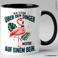 Schwarze Keramiktasse mit Flamingo und Spruch Ich stehe über den Dingen meistens auf einem Bein