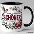 Schwarze Keramiktasse mit Kolibri-Blumenmotiv und Spruch Du machst die Welt schöner